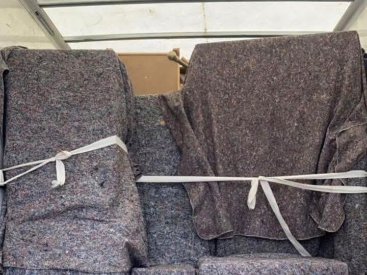Furniture wrapped in removal blankets and strapped securely inside the van