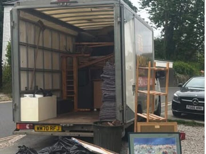 AJC Removals van being loaded with furniture and bagged waste during a property clearance
